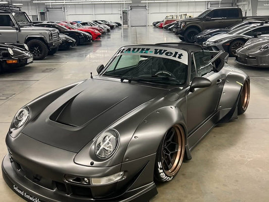 Gray sports car with 'Rauh-Welt' branding in a showroom setting
