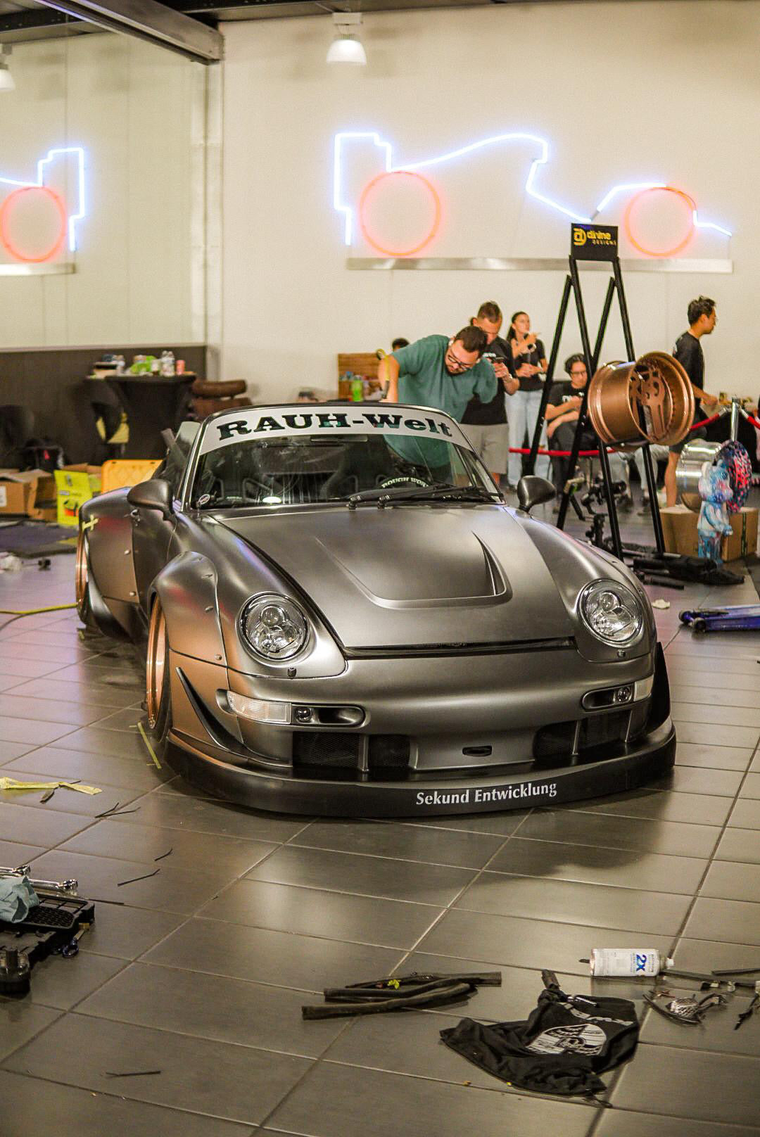 Silver Porsche with 'Rauh-Welt' branding in a garage setting.