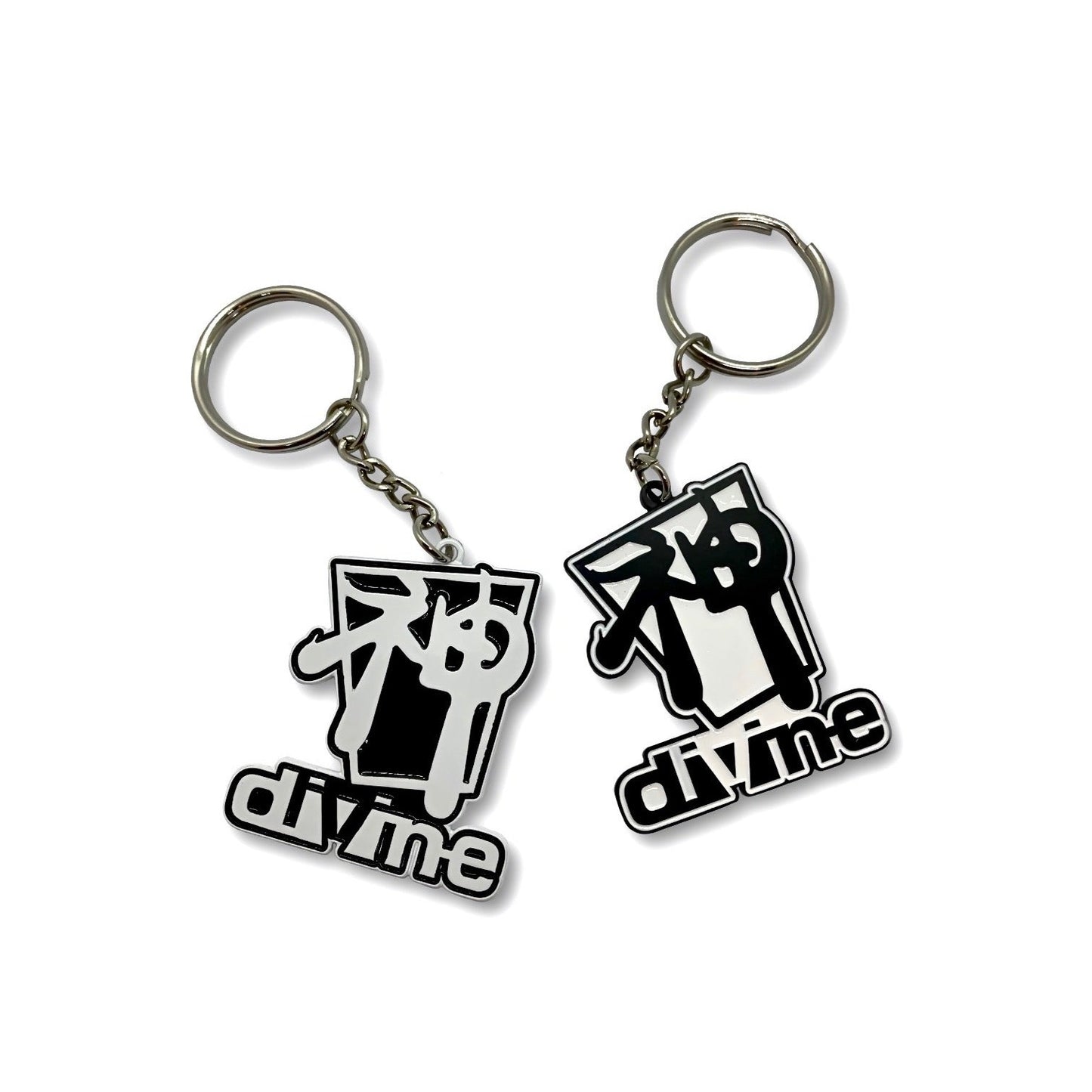 Two black and white metal keychains with the word 'DIVINE' inscribed on them.