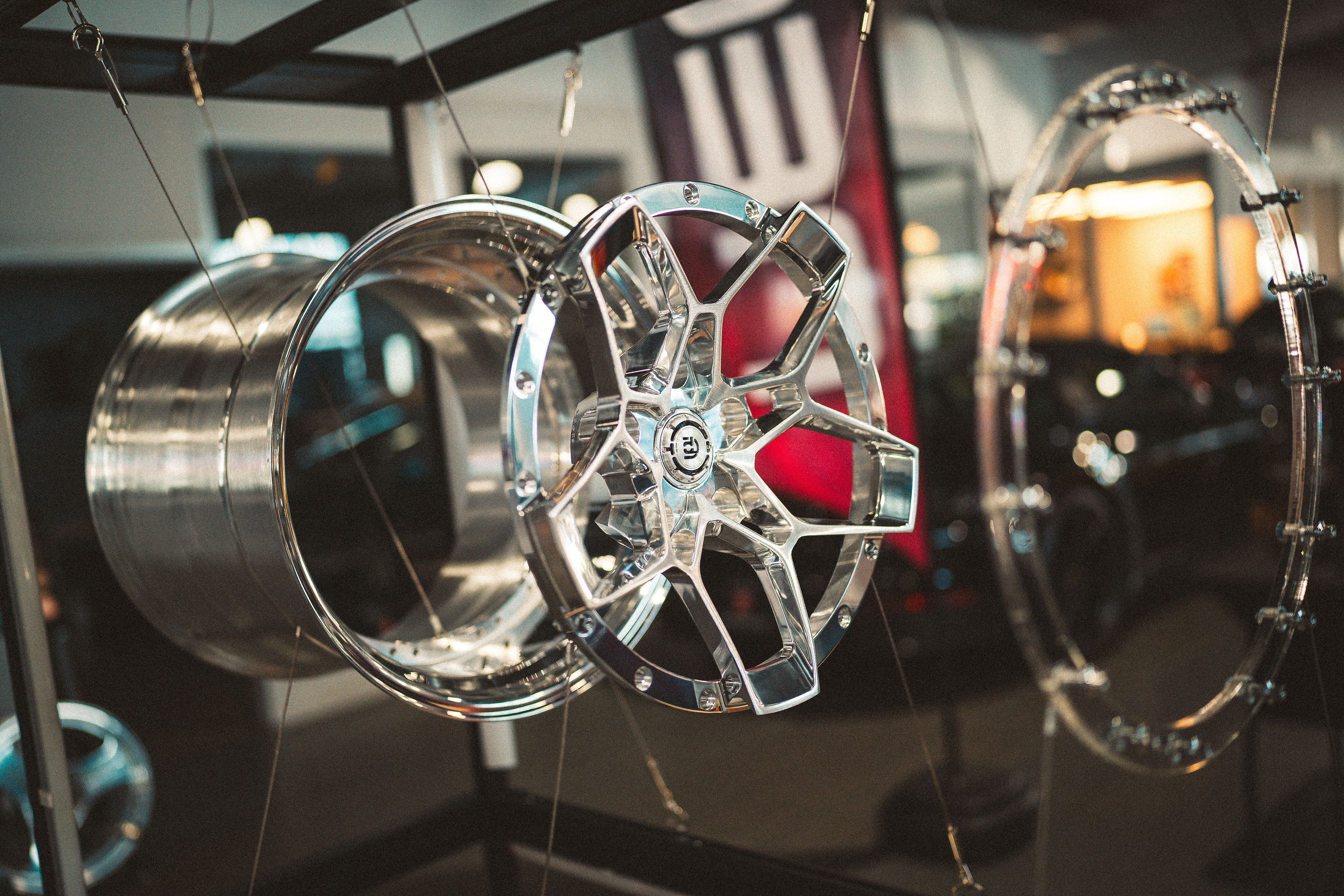 Chrome car rims displayed in a showroom setting