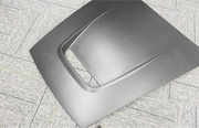 Carbon fiber hood on a textured gray surface