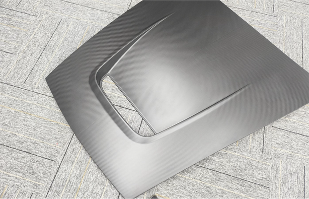 Carbon fiber hood on a textured gray surface