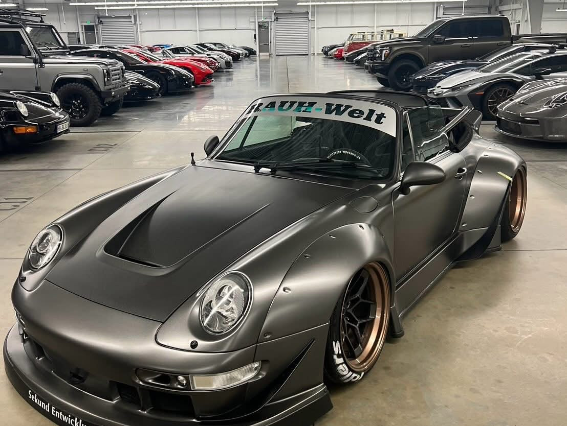 Gray sports car with 'Rauh-Welt' branding in a showroom setting