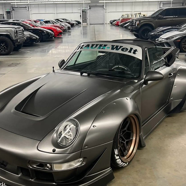 Gray sports car with 'Rauh-Welt' branding in a showroom setting