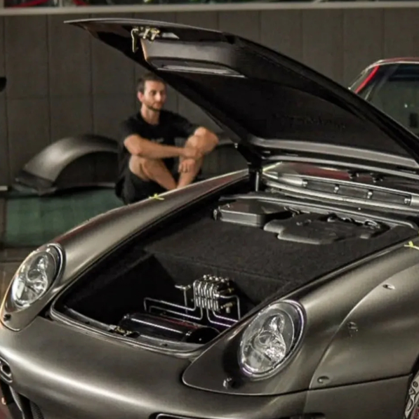 Car with open hood in a showroom setting