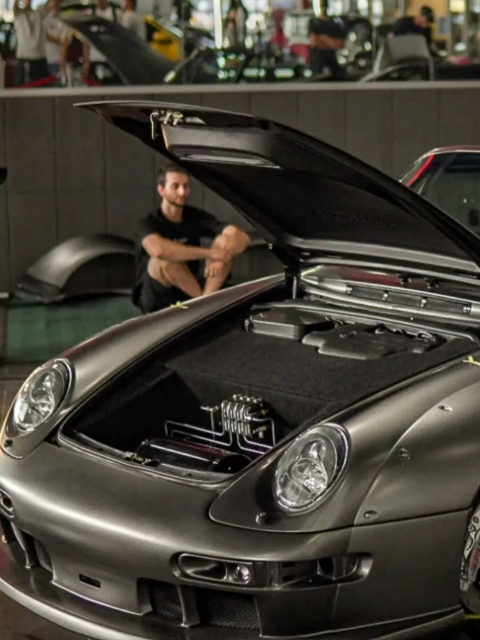 Car with open hood in a showroom setting