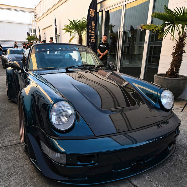 Blue sports car parked in front of a building with palm trees