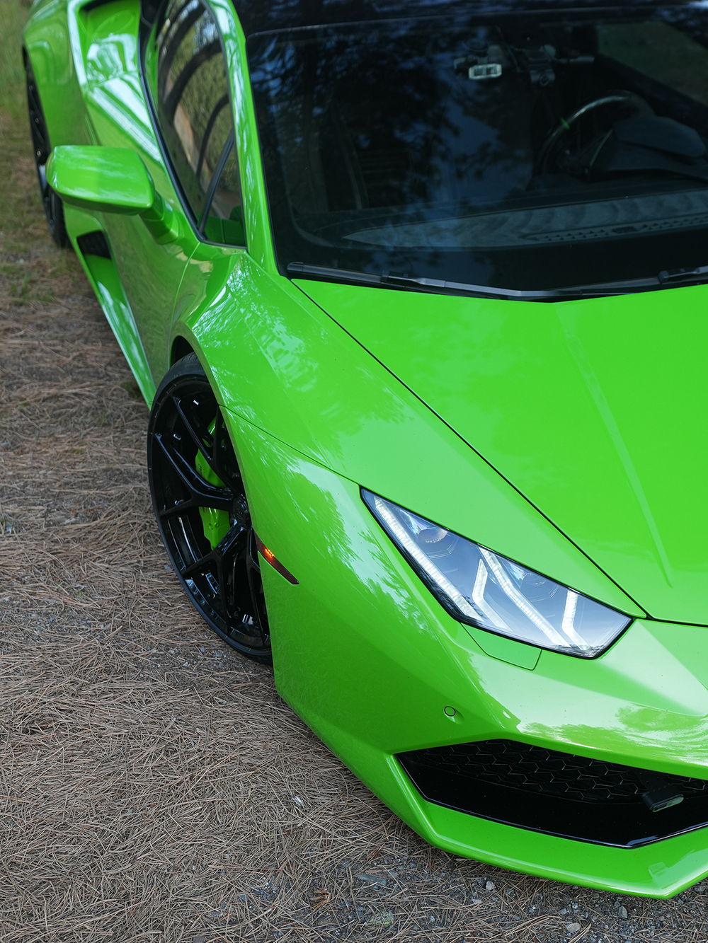 Close-up of a green sports car on a textured surface