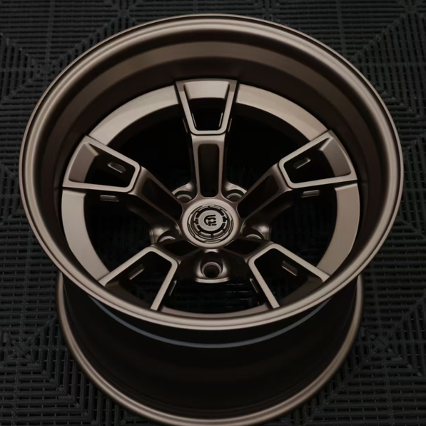 Close-up of a metallic car wheel rim on a dark textured background