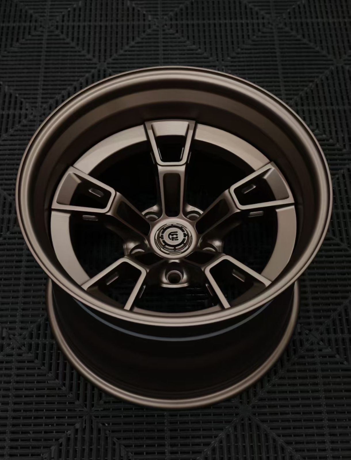 Close-up of a metallic car wheel rim on a dark textured background