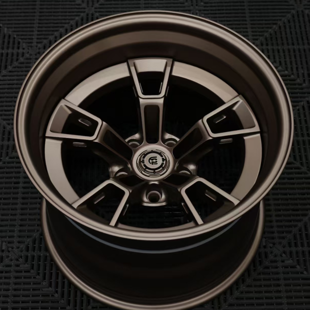 Close-up of a metallic car wheel rim on a dark textured background
