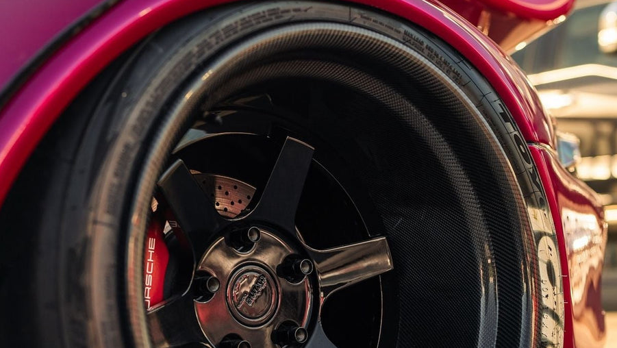 Close-up of a red car wheel with a visible logo.