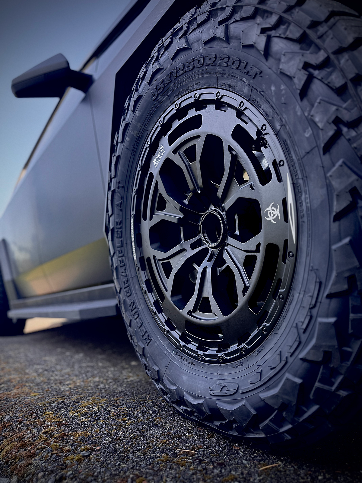 Close-up of a car tire with a detailed tread pattern on a road.
