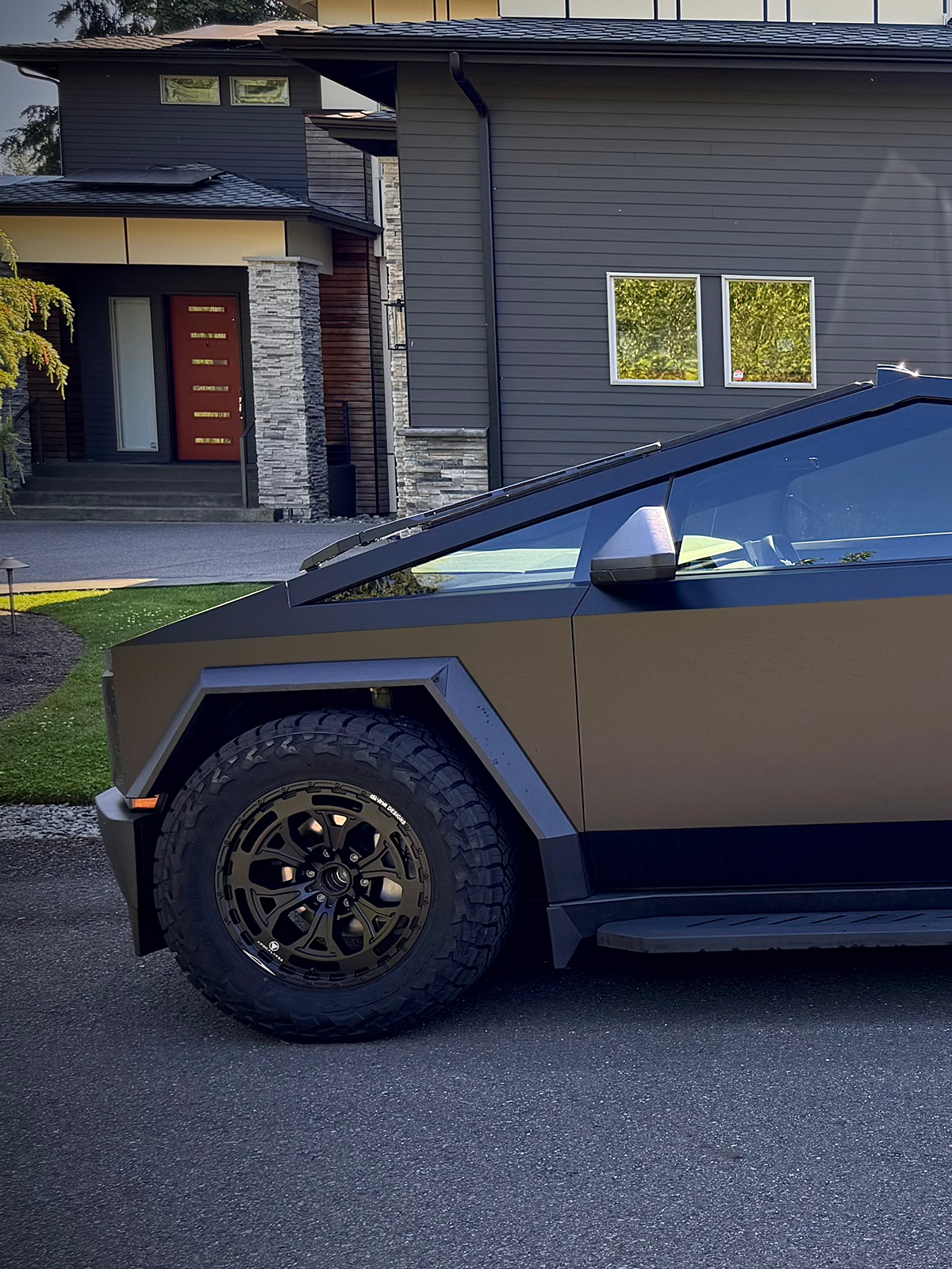 Car with custom wheels parked in front of a house