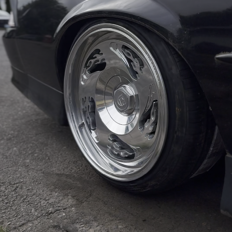 Close-up of a car wheel with a shiny hubcap on a black background