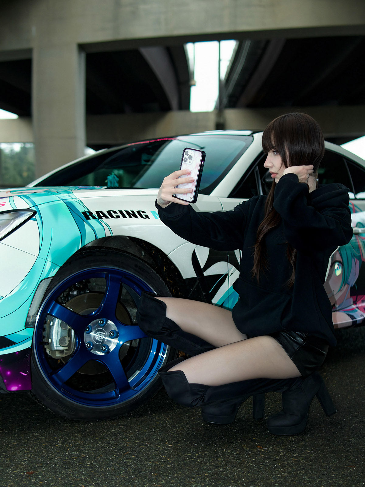 Woman taking a selfie next to a colorful racing car