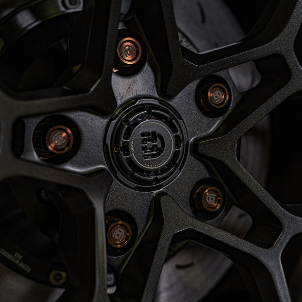 Close up of wheel with bronze branded titanium lug nuts