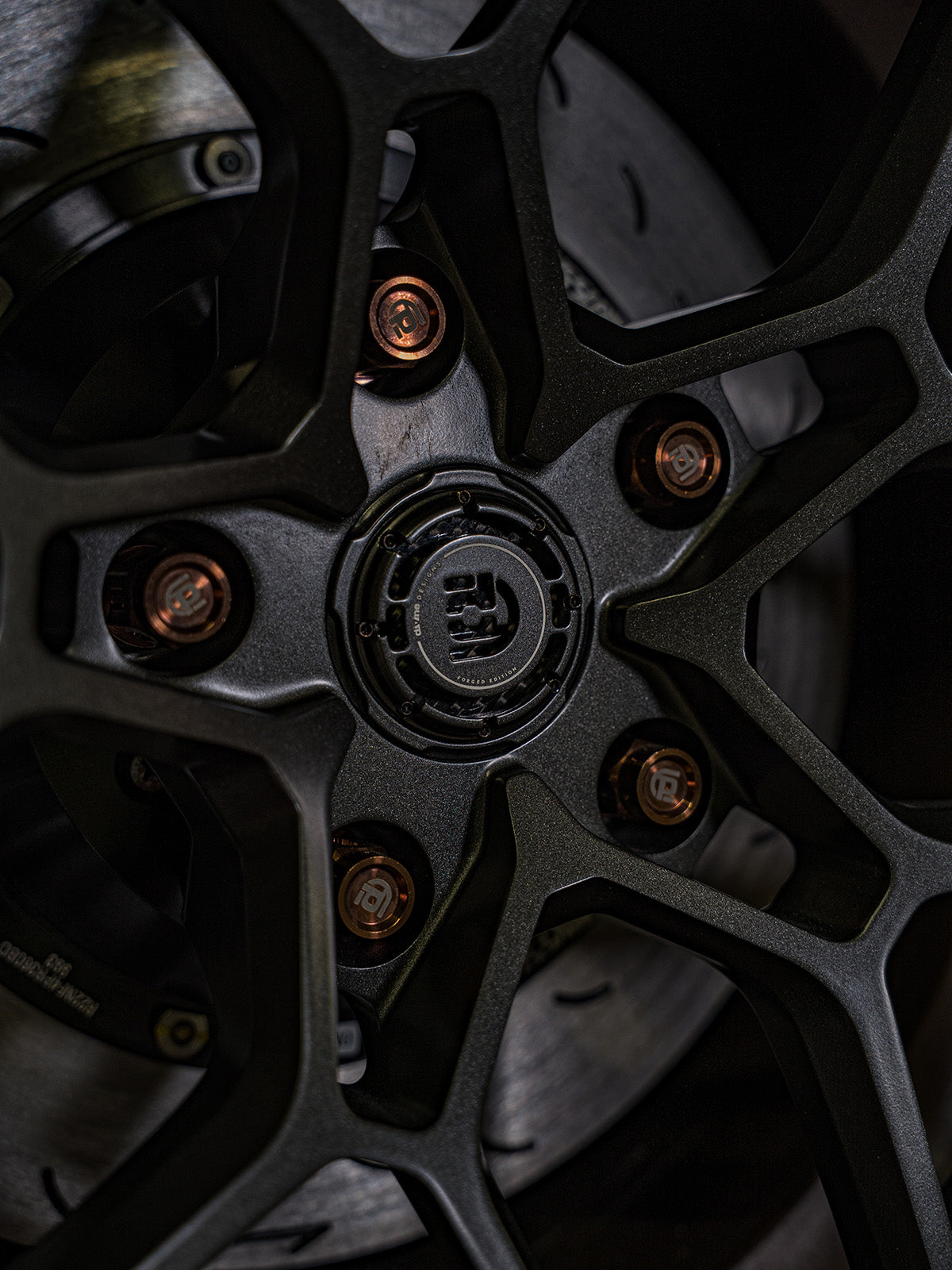 Close up of wheel with bronze branded titanium lug nuts