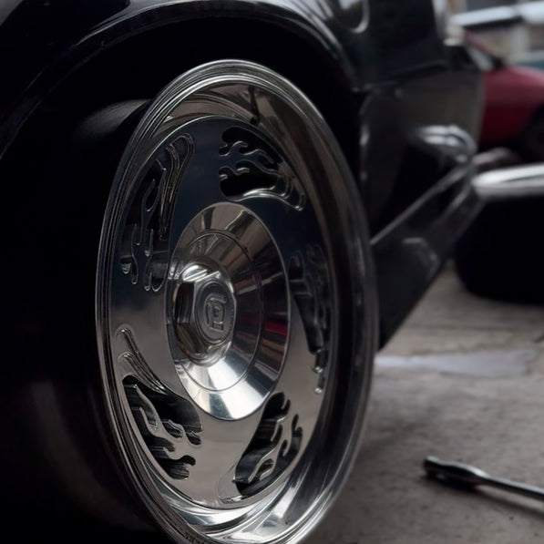Close-up of a shiny chrome wheel on a vehicle, with a blurred background.
