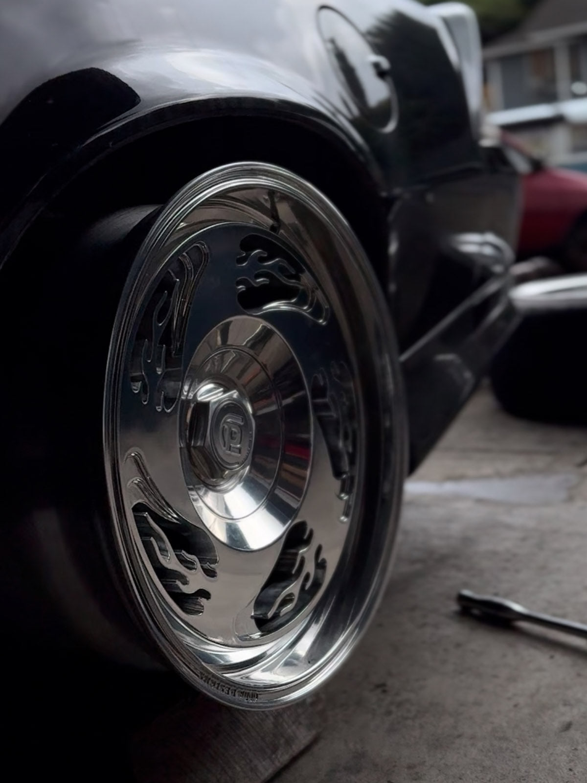 Close-up of a shiny chrome wheel on a vehicle, with a blurred background.