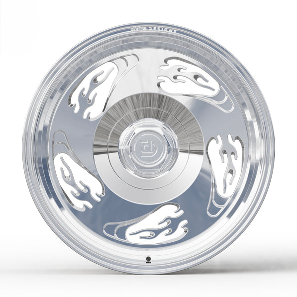 Chrome car wheel with decorative flame cutouts on a white background