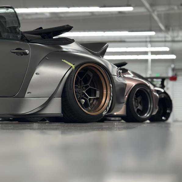 Gray sports car with custom wheels in a garage setting
