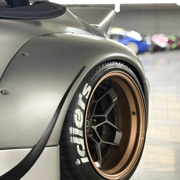Close-up of a car wheel with branding in a garage setting
