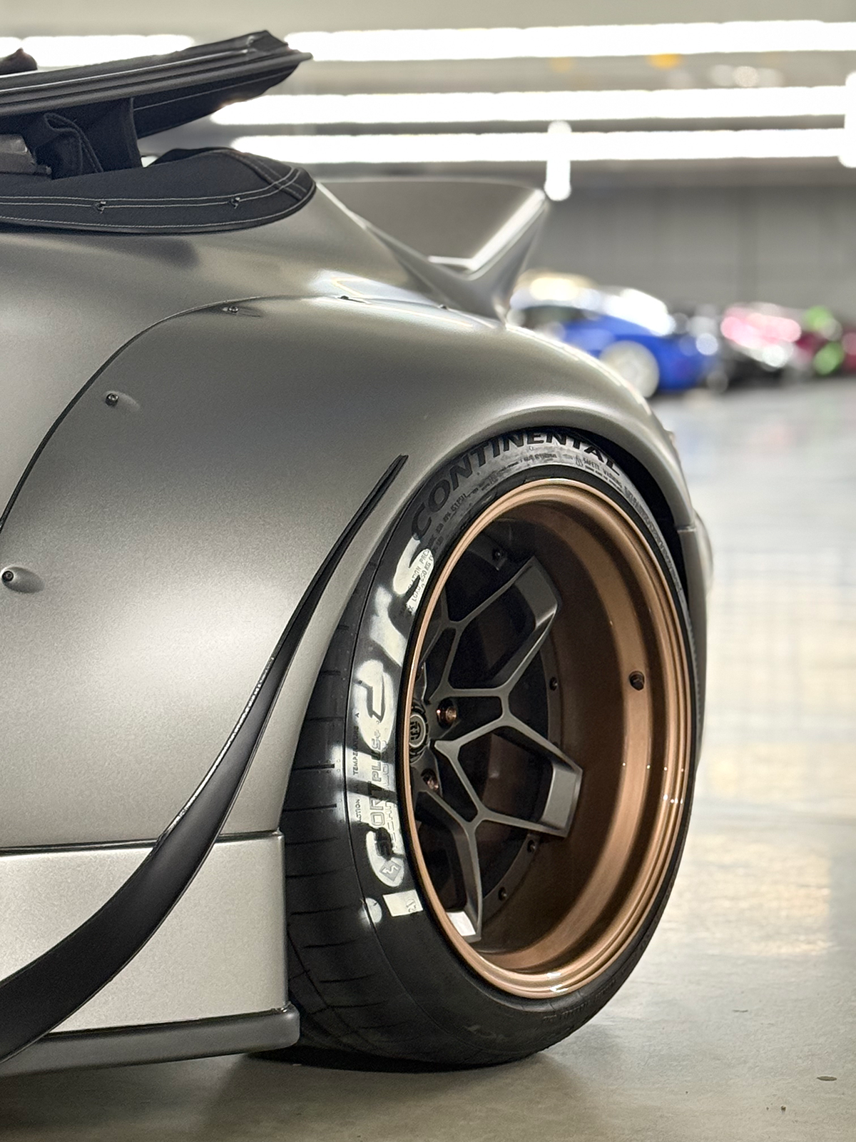 Close-up of a car wheel with branding in a garage setting