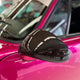 Close-up image of a one-piece seamless carbon fiber aero mirror for Porsche vehicles, displayed on a red car.