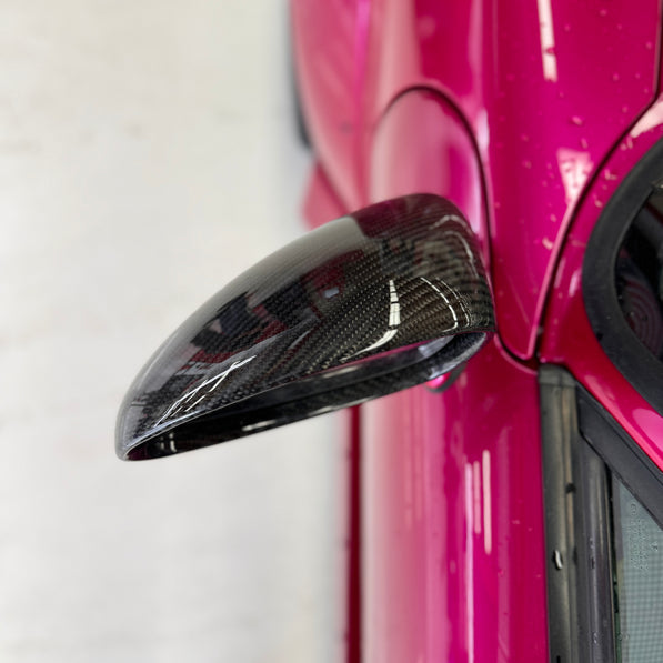 Close-up image of a one-piece seamless carbon fiber aero mirror for Porsche vehicles