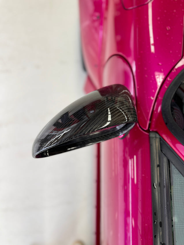 Close-up image of a one-piece seamless carbon fiber aero mirror for Porsche vehicles