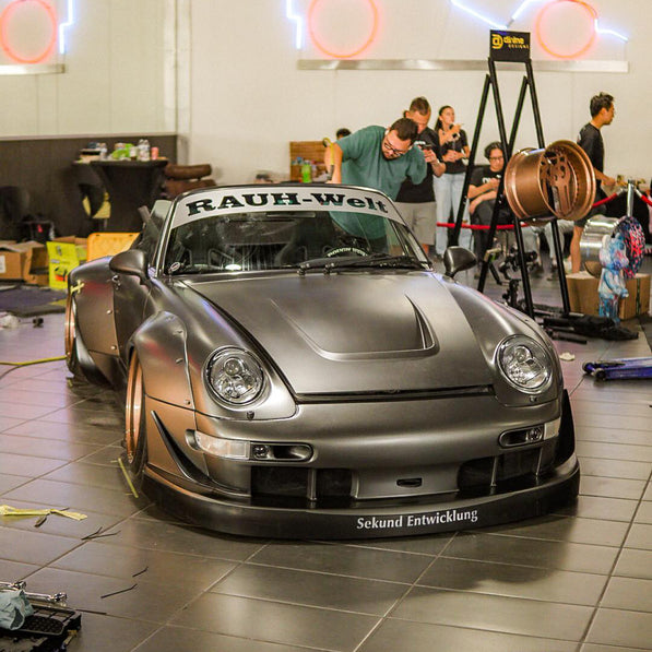 Silver Porsche with 'Rauh-Welt' branding in a garage setting.