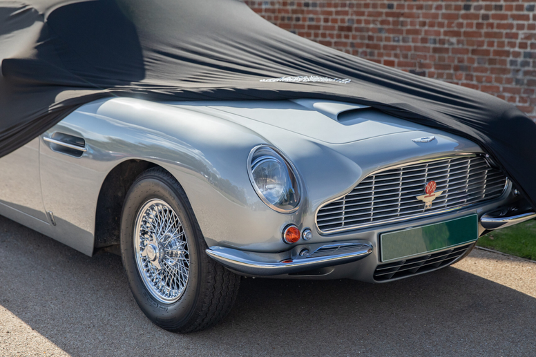 Luxury car with custom cover partially covering it