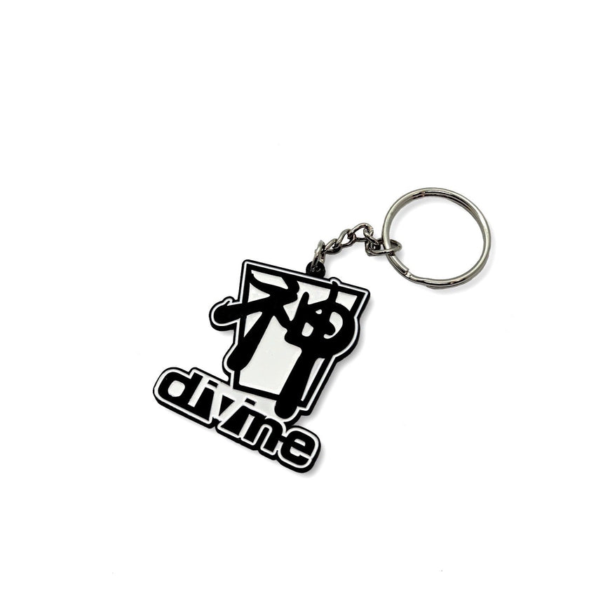 A black and white metal keychain with the word 'DIVINE' inscribed on it.