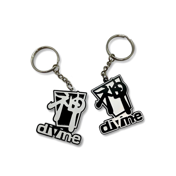 Two black and white metal keychains with the word 'DIVINE' inscribed on them.
